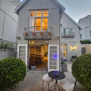 A house with a table and chairs in front of it at Cherry Tree House, Newlands in Cape Town
