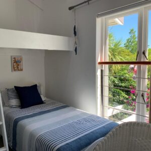 A bedroom with a bed and a large window at Chez Pierre in Knysna