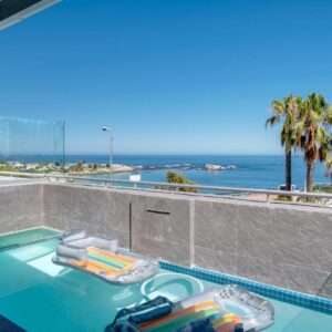 A swimming pool with a view of the ocean at Clifton Palm Views in Cape Town
