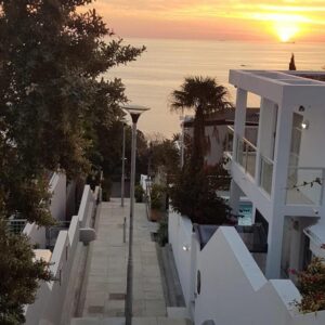 A view of a street with the sunset in the background at Clifton Steps in Cape Town