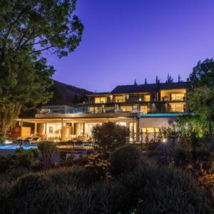 A large house with lights on at night at Clouds Estate in Stellenbosch