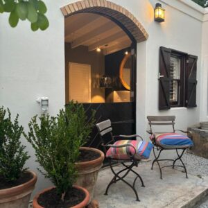 A patio with two chairs and a table at Constantia Calm, Constantia in Cape Town