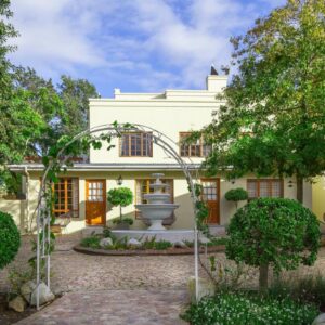 A large white house with a fountain in the yard at Cultivar Boutique Hotel in Stellenbosch