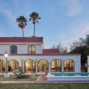 A large white house with a pool and palm trees at Deux Frères Wine Estate & Luxury Villas in Stellenbosch