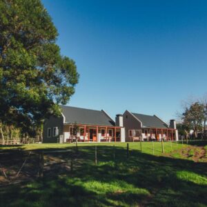 A large house with a tree in front of it at Dolittle Cottages in Swellendam