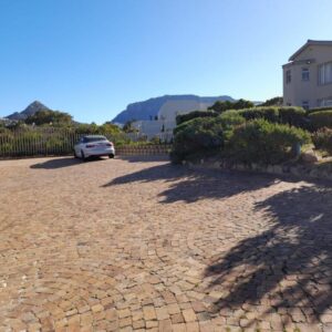 A car parked in a driveway next to a house at Dune Lodge in Hout Bay
