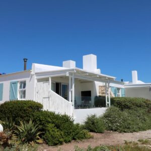 A white house on the beach at Dune Ridge Cottage in Paternoster
