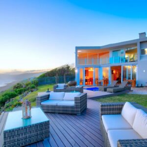 A house with a deck with furniture and the beach at Dune Villa Wilderness in Wilderness