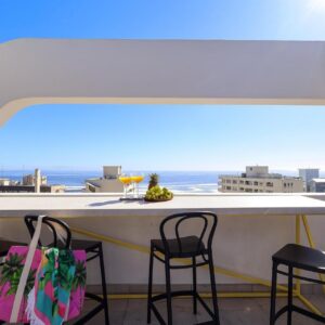 A bar with chairs and a view of the ocean at EIGHTY2 ON M - Fluent Serviced Apartments in Cape Town