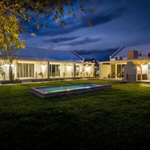 A house with a pool in the yard at night at El Dorado Hotel and Self Catering in Oudtshoorn