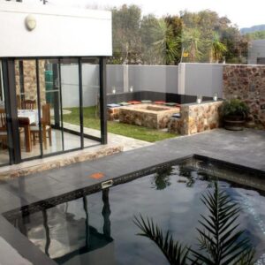 A swimming pool in the backyard of a house at Elizabeth House in Hermanus