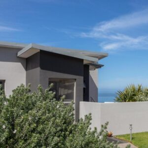 A house with the ocean in the background at Erika27 Top B&B Choice in Dana Bay