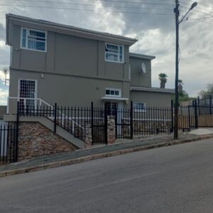 A house with a fence in front of a street at Faranie Guesthouse in Oudtshoorn