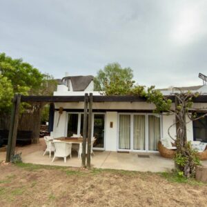 A house with a patio with a table and chairs at Featherwood Cottage in Malgas