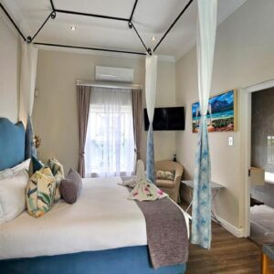 A bedroom with a bed with a blue canopy at Fleur du Soleil Luxury Guesthouse in Franschhoek