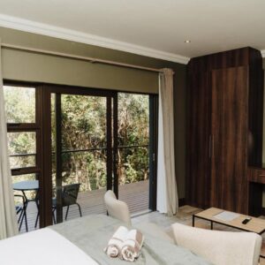 A hotel room with a bed and a large window at Forest Hill Wilderness in Wilderness