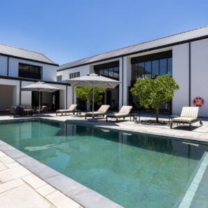 A swimming pool in front of a house at Franschhoek Hotel in Franschhoek