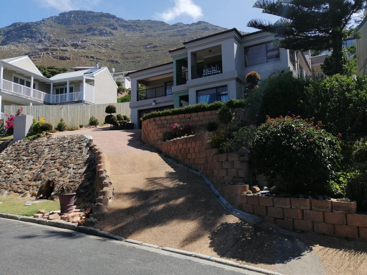 A house with a retaining wall and a driveway at Froggy at the Pond in Simonʼs Town
