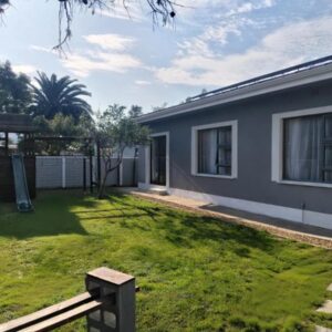 A house with a yard with a bench in front of it at Garden Route Retreat in George