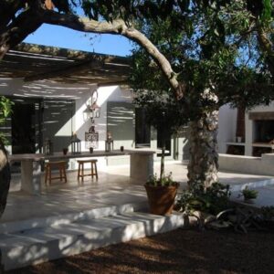 A patio with a table and a tree at Gelukkie in Paternoster