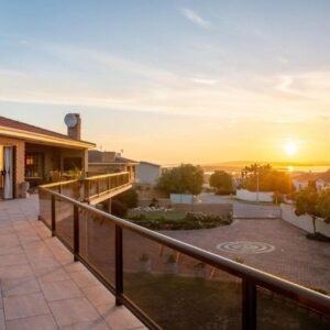 A balcony of a house with the sunset in the background at Glenfinnan Guest House in Langebaan