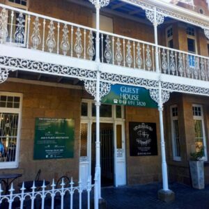 A building with a balcony on the side of it at Green Door Guesthouse in Mossel Bay