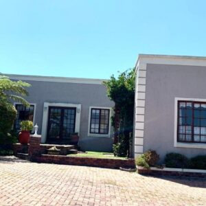 A house with a brick driveway in front of it at Green Pastures Guesthouse in George