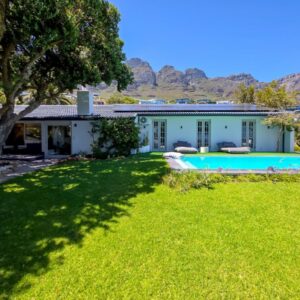 The single-storey house, lawn and swimming pool below the Twelve Apostles at Gryphon House Camps Bay in Cape Town