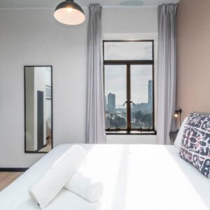 A bedroom with a large bed with a large window at HAVN Aparthotel by Totalstay in Cape Town