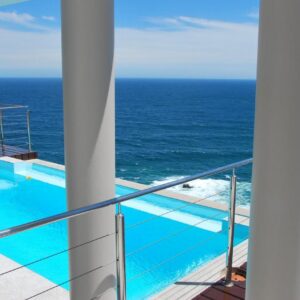 A balcony with a swimming pool and the ocean at Head over Hills in Knysna