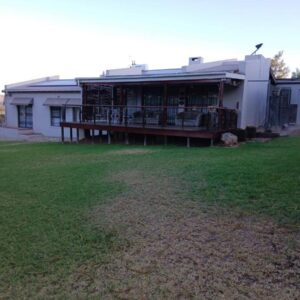 A house with a porch and a yard at Healboys Self - catering Accommodation in Bonnievale