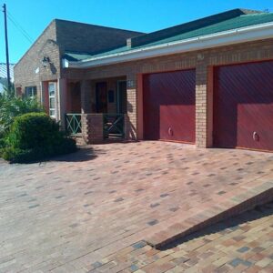 Two red garage doors on a brick building at Hinterheim in Lambertʼs Bay