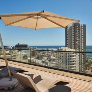 A patio with an umbrella and a bench on a roof at Home Suite Hotels Station House in Cape Town