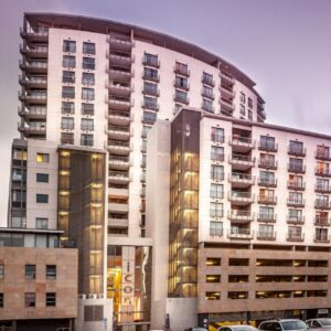 A tall white building with cars parked in front of it at Icon Serviced Apartments Foreshore in Cape Town