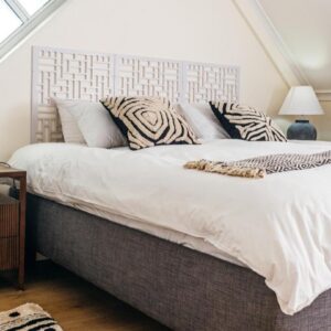 A bedroom with a large white bed with zebra pillows at Ikhaya Boutique Hotel in Cape Town