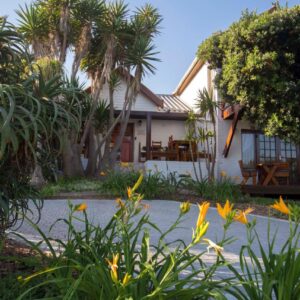 A house with trees and plants in front of it at Inn2Wilderness Guesthouse in Wilderness