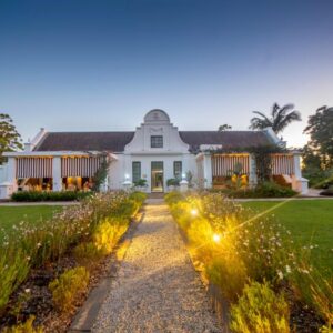 A house with a garden with lights in front of it at Lairds Lodge Country Estate in Plettenberg Bay