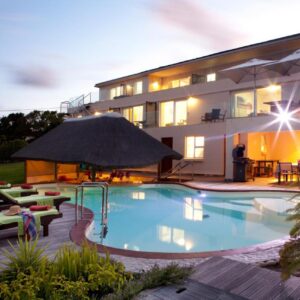 A swimming pool in front of a house at Lala Panzi B&B in Plettenberg Bay