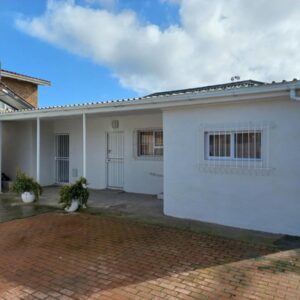 A white house with a brick driveway at Lazy Days Apartments - Lambert's Bay in Lambertʼs Bay