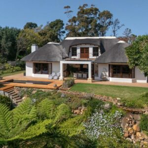 A large white house with a thatched roof at Leopard Lodge in Hermanus