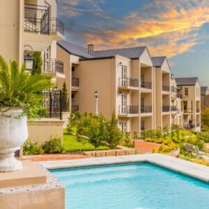A villa with a swimming pool in front of a building at W-Collection Franschhoek L'Ermitage Villas in Franschhoek