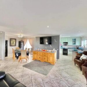 A large living room with a couch and a table at Lilies and Leopards Holiday Home B & B in Mossel Bay