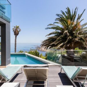 A house with a swimming pool and a balcony with chairs at Living Hotel Lion's Eye in Cape Town