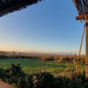 The covered stoep of Living The Breede – Inhoek Farm Gatehouse looking over the farmland near Malgas