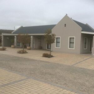 A large white building with a driveway at Longacre Olive & Vineyard Estate in Langebaan