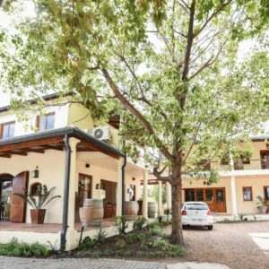 A white car parked in front of a building at Lovane Boutique Wine Estate and Guesthouse in Stellenbosch