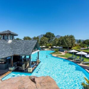 A pool at a resort with chairs and umbrellas at Luxury Lodge 5D, Pearl Valley Golf Estate in Simondium