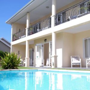 A house with a swimming pool in front of it at Mandalay Guest House Plettenberg Bay in Plettenberg Bay