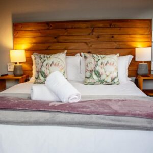 A bedroom with a large bed with two lamps at MegaBean Guest Rooms & Coffee Shop in Swellendam
