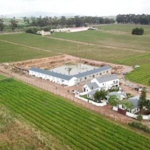 An aerial view of a large white building in a field at Middelplaas Paarl Guesthouse in Paarl